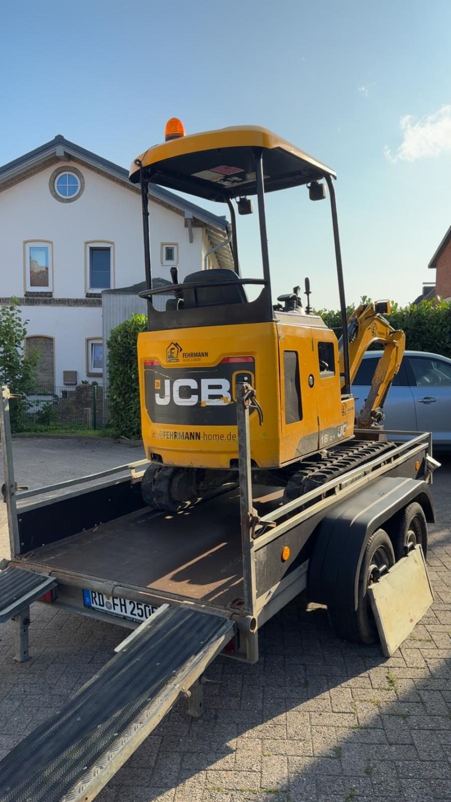 JCB 16C-1 von Fehrmann Home & More verladen auf dem Anhänger